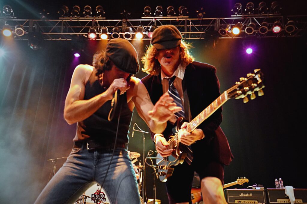 Two members of the band Back in Black performing on stage